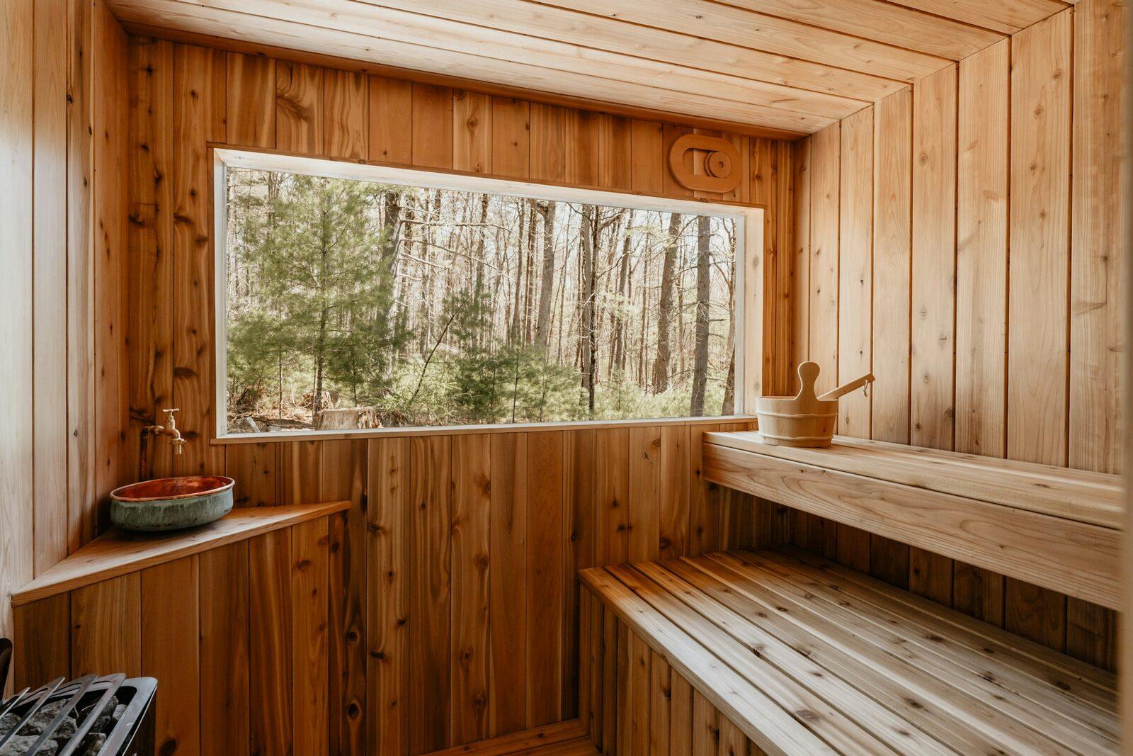 The inside of a wooden sauna opening onto the forest